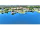 Stunning aerial view of a lake with a dock, community clubhouse, and surrounding landscape at 104 La Cresta Ct, Davenport, FL 33837