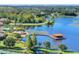 Scenic aerial view featuring a lake with a gazebo, swimming pool and community amenities at 104 La Cresta Ct, Davenport, FL 33837