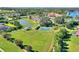 Aerial view of the community with a playground, lake, basketball court and plenty of green space at 104 La Cresta Ct, Davenport, FL 33837