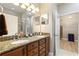 Bathroom featuring double vanity with granite counters, a walk-in shower, and an open doorway to a walk-in closet at 104 La Cresta Ct, Davenport, FL 33837