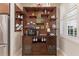 Stylish coffee bar area with dark wood cabinets, open shelving, a Keurig coffee maker, and a mini beverage refrigerator at 104 La Cresta Ct, Davenport, FL 33837