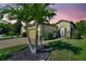 Beautiful home with a well manicured lawn and lush landscaping, including mature palm trees at 104 La Cresta Ct, Davenport, FL 33837