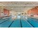 Bright indoor pool featuring marked lanes, natural lighting, and stone accent walls at 104 La Cresta Ct, Davenport, FL 33837