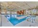 Bright indoor pool area with natural light, safety equipment, and zero entry access at 104 La Cresta Ct, Davenport, FL 33837