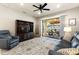 Cozy living room with a ceiling fan, comfortable leather seating, a built-in entertainment center, and patio access at 104 La Cresta Ct, Davenport, FL 33837
