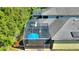 Aerial view of a large screened-in patio with an umbrella, solar panels and backyard at 104 La Cresta Ct, Davenport, FL 33837