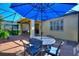 Outdoor living space with brick patio, blue umbrella, seating and view to the yard and house at 104 La Cresta Ct, Davenport, FL 33837