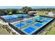 Outdoor pickleball and tennis courts with green and blue surfaces, surrounded by fencing and green landscaping at 104 La Cresta Ct, Davenport, FL 33837
