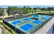 Community pickleball courts featuring multiple blue courts, green surfaces, and shaded seating areas at 104 La Cresta Ct, Davenport, FL 33837