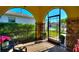 Covered front porch with brick flooring, stone columns, and a view of the landscaped front yard at 104 La Cresta Ct, Davenport, FL 33837