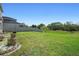Landscaped backyard featuring a well-maintained lawn, privacy fence and a charming outdoor seating area at 1246 Maplebrook Dr, Lake Alfred, FL 33850