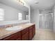 Bathroom featuring dual sinks, a large mirror, and a glass-enclosed shower at 1246 Maplebrook Dr, Lake Alfred, FL 33850