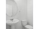 Bathroom featuring a white sink, toilet, and large round mirror at 1246 Maplebrook Dr, Lake Alfred, FL 33850