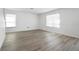 Bedroom with wood floors featuring two windows providing natural light at 1246 Maplebrook Dr, Lake Alfred, FL 33850