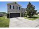 Two-story home features a black two-car garage, gray siding, and a large tree in the front yard at 1246 Maplebrook Dr, Lake Alfred, FL 33850
