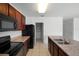 Kitchen featuring wood cabinets, black appliances, neutral counters, and a walk-in pantry at 1246 Maplebrook Dr, Lake Alfred, FL 33850