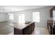 Bright kitchen featuring an island with stainless steel dual basin sink and open access to the living room at 1246 Maplebrook Dr, Lake Alfred, FL 33850