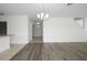 Open-concept living room featuring light gray wood floors and a chandelier at 1246 Maplebrook Dr, Lake Alfred, FL 33850
