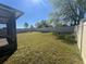 A fenced-in backyard with a grassy lawn and young trees offers plenty of room to play and unwind at 1249 Oak Valley Dr, Auburndale, FL 33823