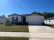 Charming single-story home with manicured lawn, attached garage, and welcoming entrance at 1249 Oak Valley Dr, Auburndale, FL 33823