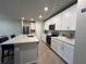 Kitchen featuring a central island with seating, complemented by stainless appliances and white cabinetry, providing ample storage space at 1249 Oak Valley Dr, Auburndale, FL 33823