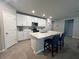 Modern kitchen with white cabinets, quartz countertops, and a spacious island with bar seating at 1249 Oak Valley Dr, Auburndale, FL 33823