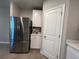 Kitchen area featuring stainless steel refrigerator, white cabinets, and convenient access to storage spaces at 1249 Oak Valley Dr, Auburndale, FL 33823