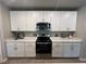 Kitchen featuring stainless steel oven and microwave appliances against a backdrop of white upper and lower cabinets at 1249 Oak Valley Dr, Auburndale, FL 33823