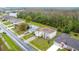 An aerial view of a house with solar panels, a well-manicured lawn, and a lake nearby at 147 Pompei Dr, Kissimmee, FL 34758