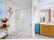 Bright bathroom featuring a walk-in shower with glass door and double vanity at 147 Pompei Dr, Kissimmee, FL 34758