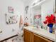Bright bathroom featuring a vanity with storage, floral decor, and fun decorations at 147 Pompei Dr, Kissimmee, FL 34758