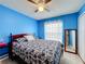 Blue bedroom with patterned bedding, a side table, and a full-length mirror at 147 Pompei Dr, Kissimmee, FL 34758