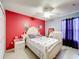 Cozy bedroom featuring a bright red accent wall and decorative touches at 147 Pompei Dr, Kissimmee, FL 34758