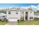 Two-story stucco home with solar panels, attached garage, and covered front entrance at 147 Pompei Dr, Kissimmee, FL 34758