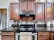 A kitchen featuring granite counters, wood cabinets, and stainless steel appliances and tiled backsplash at 147 Pompei Dr, Kissimmee, FL 34758