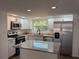Well-lit kitchen features stainless steel appliances, granite countertops, and a functional island at 1539 Roselawn Sw St, Winter Haven, FL 33880