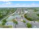 A beautiful aerial view of a townhome community with a pond, tennis courts, and lush landscaping at 2200 San Vittorino Cir # 105, Kissimmee, FL 34741