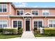 Charming townhome exterior with tidy landscaping, a picket fence, and a welcoming front door at 2200 San Vittorino Cir # 105, Kissimmee, FL 34741