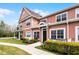 Two story townhome features tidy landscaping, a picket fence and covered front porch at 2200 San Vittorino Cir # 105, Kissimmee, FL 34741