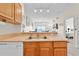 Well-lit kitchen with stainless steel sink and a view into the living room and bedroom at 2200 San Vittorino Cir # 105, Kissimmee, FL 34741