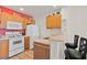 Functional kitchen with white appliances, wood cabinets, and cozy breakfast bar seating at 2200 San Vittorino Cir # 105, Kissimmee, FL 34741