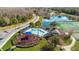 Community pool area with a playground, surrounded by palm trees and well-maintained landscaping with lake view at 2200 San Vittorino Cir # 105, Kissimmee, FL 34741