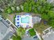 Aerial view of a sparkling blue pool with lounge chairs and umbrellas surrounded by lush trees at 2200 San Vittorino Cir # 105, Kissimmee, FL 34741