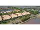 An aerial shot presents a community with tile-roofed homes, surrounded by lush trees and reflective lake waters at 2340 Palm Tree Dr, Kissimmee, FL 34759