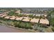 An aerial perspective shows tile-roofed homes near a lake, with manicured landscaping defining the residential community at 2340 Palm Tree Dr, Kissimmee, FL 34759