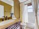 Bathroom featuring a vanity with bronze fixtures, complemented by a tub and a shower behind a shower curtain at 2340 Palm Tree Dr, Kissimmee, FL 34759