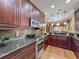 Gourmet kitchen with granite countertops, stainless steel appliances, and rich wood cabinetry at 2340 Palm Tree Dr, Kissimmee, FL 34759