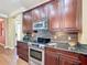 Kitchen featuring stainless steel appliances, granite countertops, and stylish dark cabinetry at 2340 Palm Tree Dr, Kissimmee, FL 34759
