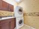Efficient laundry area with stacked washer and dryer unit and additional cabinets at 2340 Palm Tree Dr, Kissimmee, FL 34759