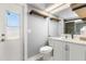 Bathroom featuring a white vanity, toilet, window and modern shelves at 2566 Conway Gardens Rd, Orlando, FL 32806